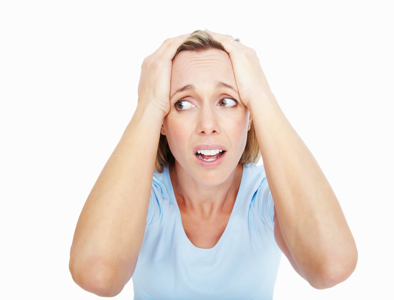 Portrait of frustrated woman with hands on head over white background