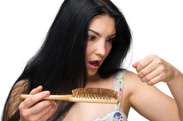 Shocked woman making a face because losing hair on hairbrush isolated on white background