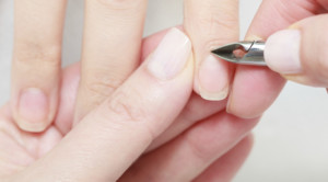 Beautician trimming cuticles of female client in beauty salon